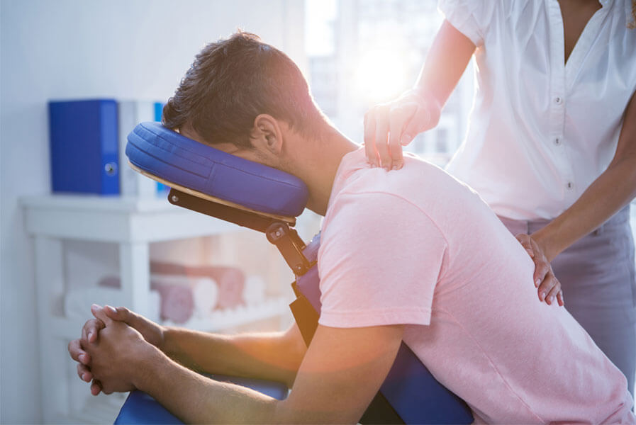 Chiropractor massaging man's back