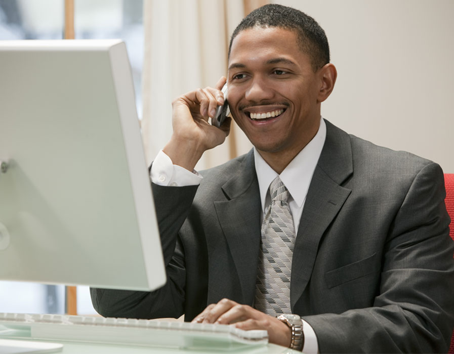 Businessman on cellphone at computer