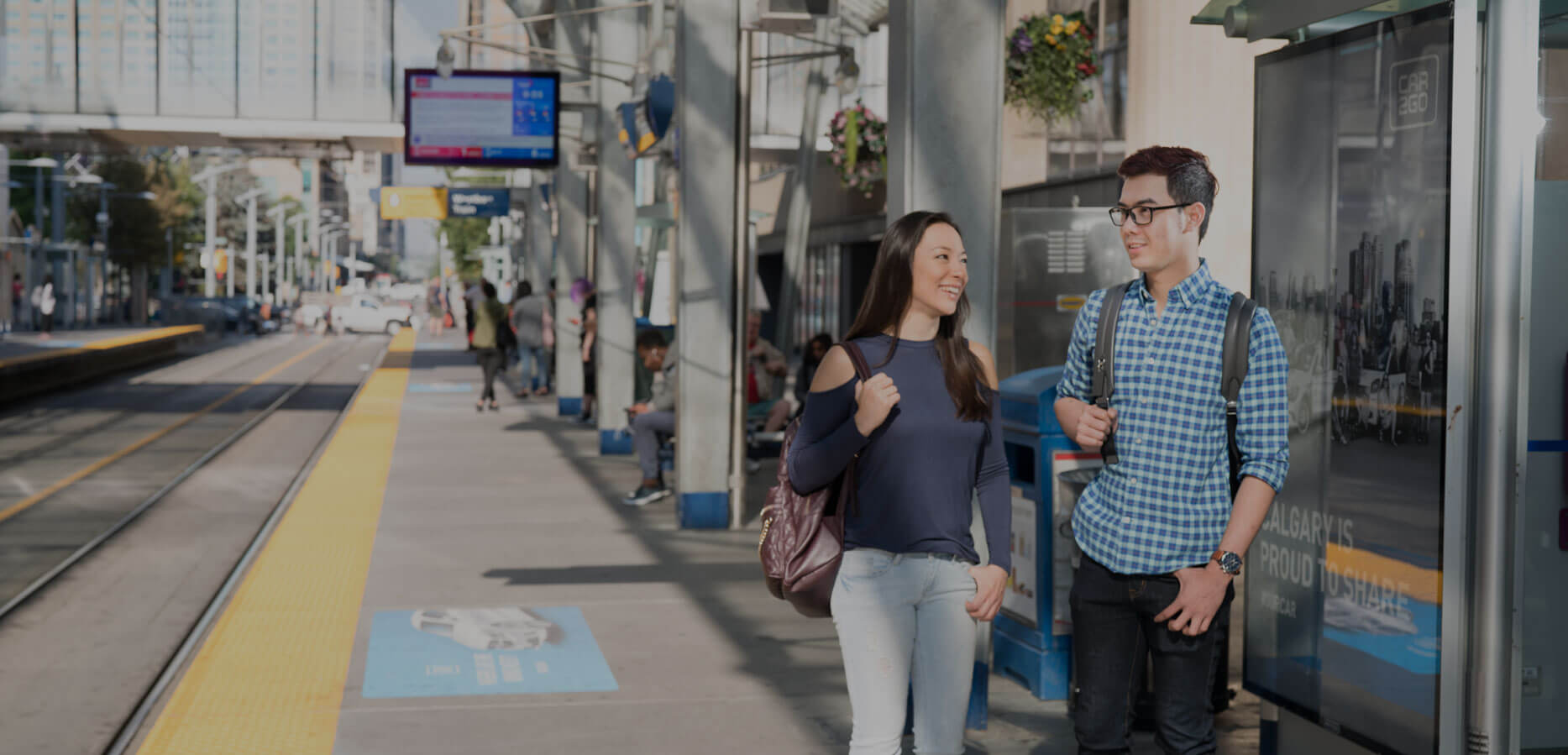 Two students standing at the C-Train platform